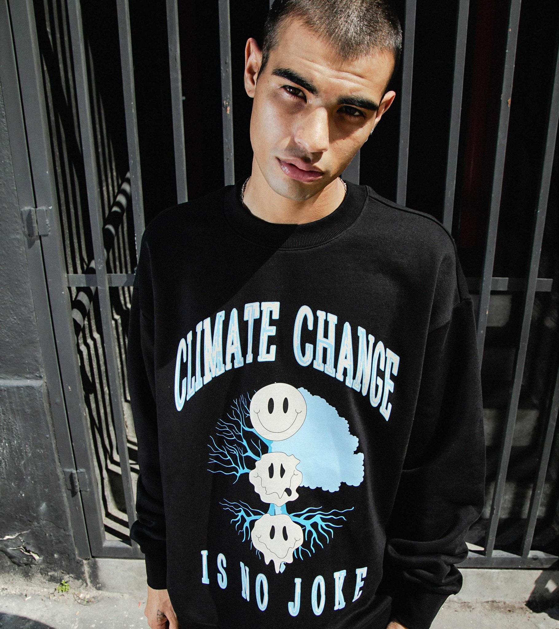 Close-up of male model in Climate Change Is No Joke oversized heavyweight crewneck sweatshirt in black