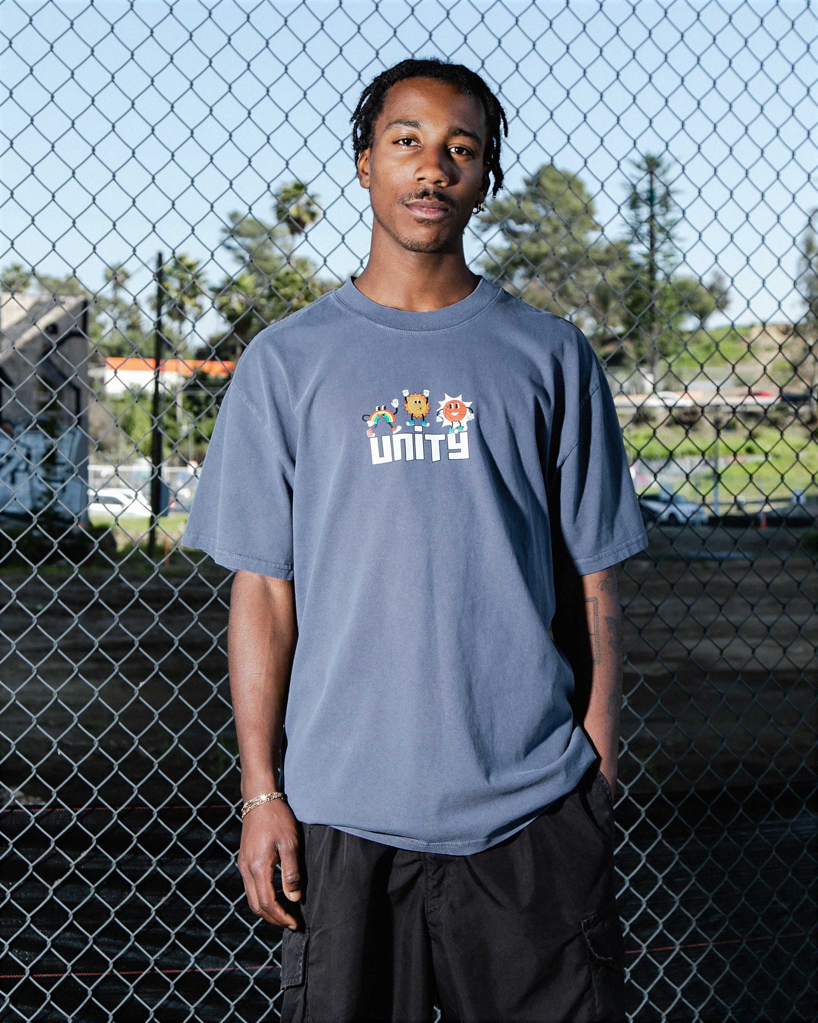 Medium-shot of male model wearing Unity oversized fit unisex cotton graphic t-shirt in faded indigo