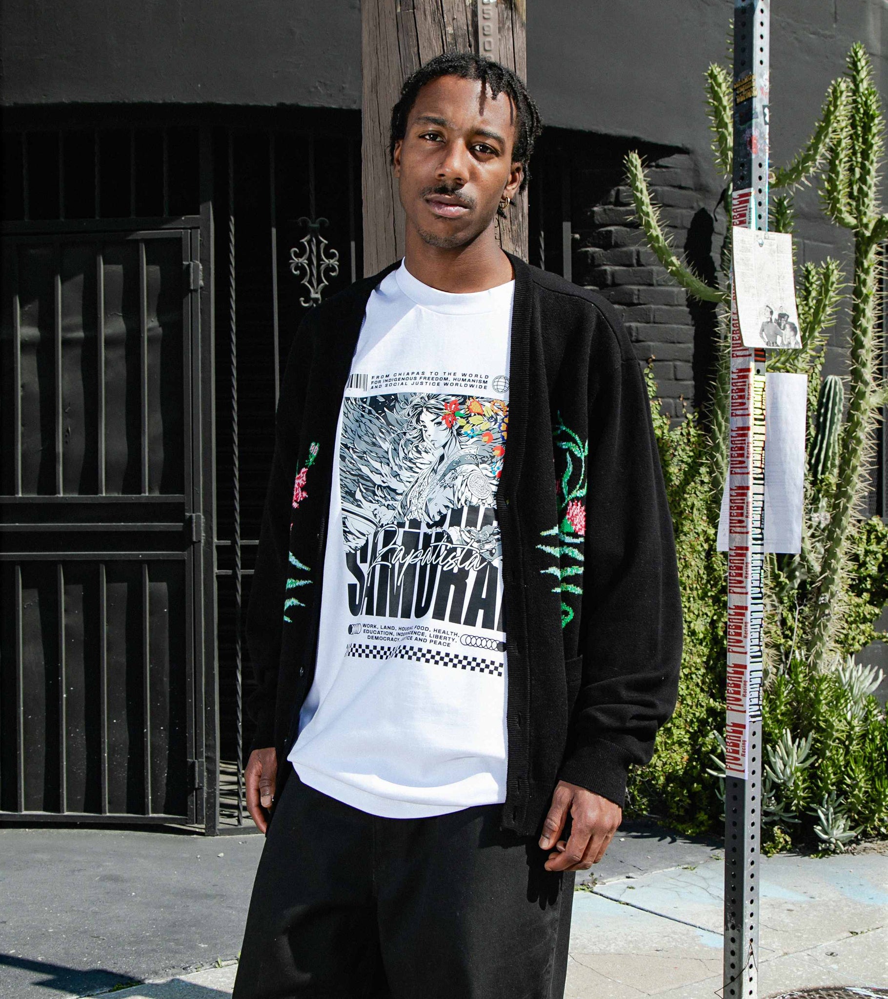 Medium shot of male model standing on street in oversized unisex cotton graphic t-shirt in white with Zapatista Samurai.